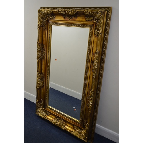 1677 - A LARGE MODERN FOLIATE GILT WOOD BEVELLED EDGE RECTANGULAR WALL MIRROR, 165CM X 105CM (sd)