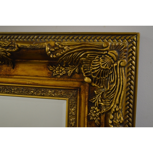 1677 - A LARGE MODERN FOLIATE GILT WOOD BEVELLED EDGE RECTANGULAR WALL MIRROR, 165CM X 105CM (sd)