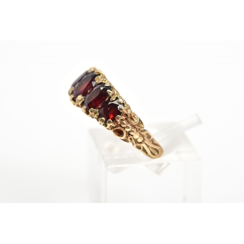 1 - A 9CT GOLD RED GLASS RING, designed as five graduated oval cut red pastes within claw settings to th... 