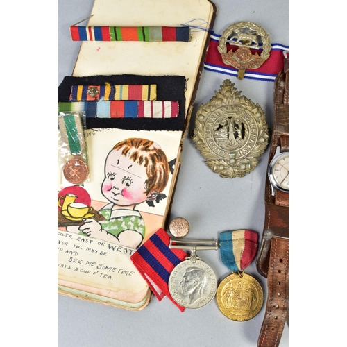 111 - A SMALL BOX OF MILITARIA, to include cap badges, two defence medals 1939-45, a military style wristw... 