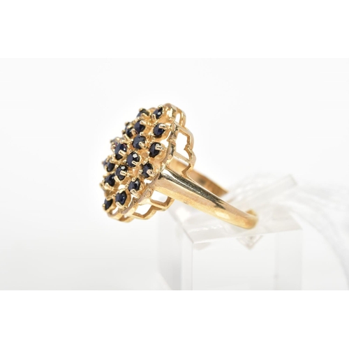 14 - A 9CT GOLD SAPPHIRE DRESS RING, designed as an openwork panel with scalloped edge, claw set with cir... 