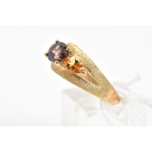 16 - A 9CT GOLD SMOKY QUARTZ AND CITRINE DRESS RING, the textured split band set with a central oval cut ... 