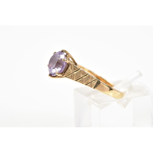 17 - A 9CT GOLD AMETHYST RING, the circular amethyst within a six claw setting to the tapered, slightly t... 