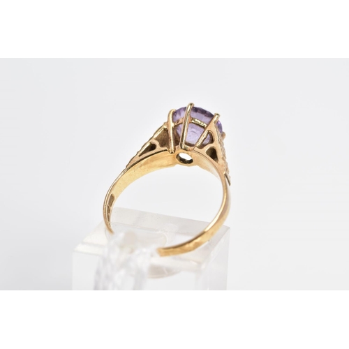 17 - A 9CT GOLD AMETHYST RING, the circular amethyst within a six claw setting to the tapered, slightly t... 