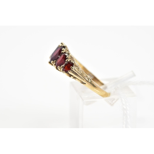 18 - A 9CT GOLD RED PASTE FIVE STONE RING, designed as five graduated oval cut red pastes to the scrollin... 