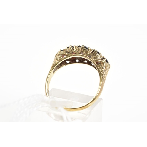 18 - A 9CT GOLD RED PASTE FIVE STONE RING, designed as five graduated oval cut red pastes to the scrollin... 