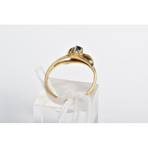 25 - A 9CT GOLD SAPPHIRE DRESS RING, of asymmetric design and split front band, diagonally set with two c... 