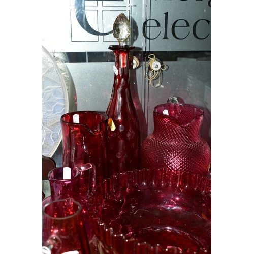 267 - A GROUP OF CRANBERRY COLOURED GLASS ITEMS, to include five various jugs, tallest 18cm, smallest 12.5... 