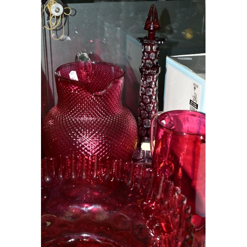 267 - A GROUP OF CRANBERRY COLOURED GLASS ITEMS, to include five various jugs, tallest 18cm, smallest 12.5... 