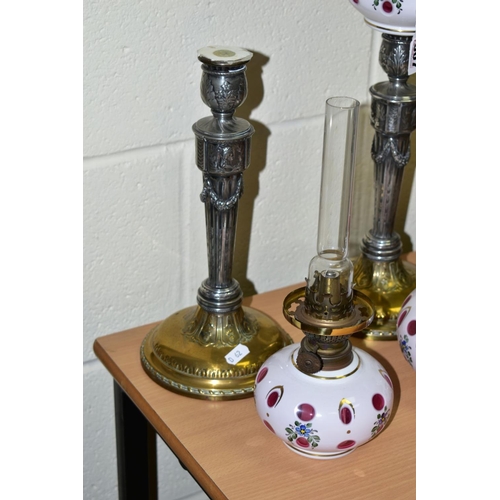 307 - A PAIR OF WMF SILVER PLATED CANDLESTICKS, converted to oil lamps by the addition of cranberry overla... 