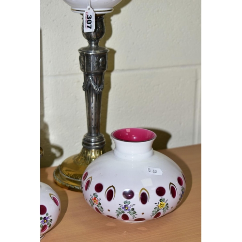 307 - A PAIR OF WMF SILVER PLATED CANDLESTICKS, converted to oil lamps by the addition of cranberry overla... 