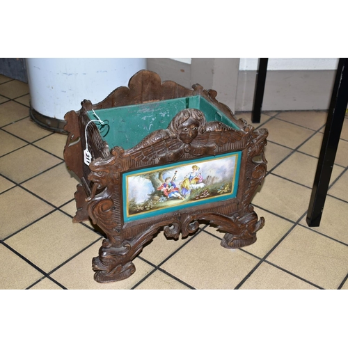 311 - A 19TH CENTURY BLACK FOREST WOODEN PLANTER, with porcelain panel depicting a male figure playing the... 