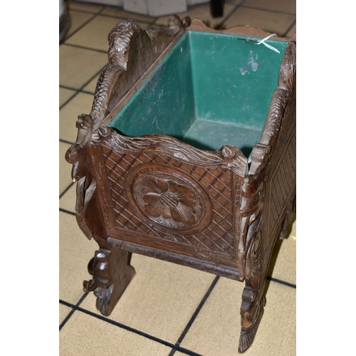 311 - A 19TH CENTURY BLACK FOREST WOODEN PLANTER, with porcelain panel depicting a male figure playing the... 