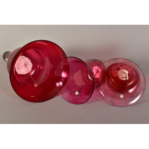 349 - THREE VICTORIAN GLASS BELLS, with cranberry tinted bowls and turned handles, of various heights, tal... 