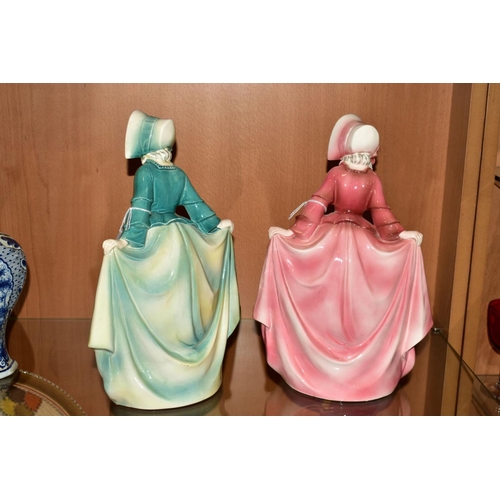 352 - TWO HERTWIG & CO KATZHUTTE PORCELAIN FIGURES, both of lady holding skirt wearing a bonnet, one in pi... 