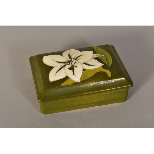 469 - A RECTANGULAR MOORCROFT POTTERY COVERED TRINKET BOX, 'Bermuda Lily' pattern on green ground, impress... 