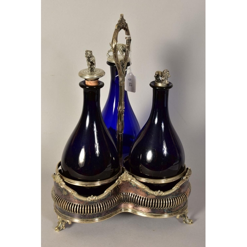 486 - A VICTORIAN PLATED TREFOIL DECANTER STAND, containing three blue glass decanters with novelty stoppe... 