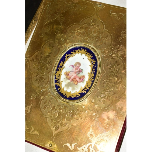 559 - A GILT METAL COVERED INK BLOTTER INSET WITH SEVRES PORCELAIN PANEL DEPICTING A CHERUB, velvet cover ... 