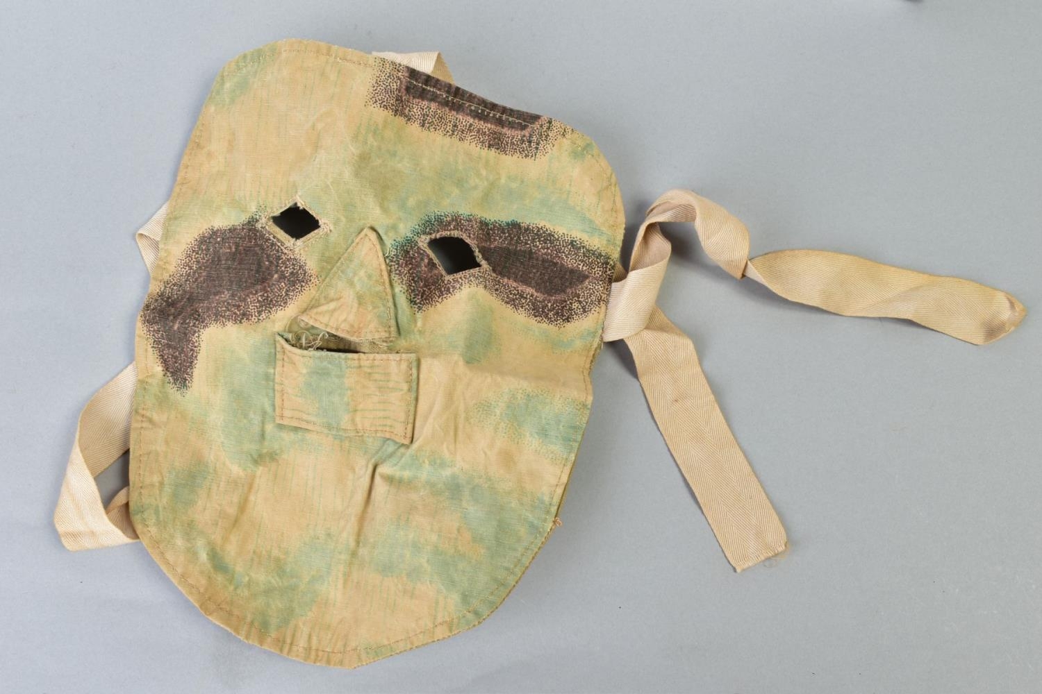 A GERMAN WWI/II ERA CANVAS/CLOTH CAMOFLOUGE SNIPER MASK, to be worn under the helmet etc,