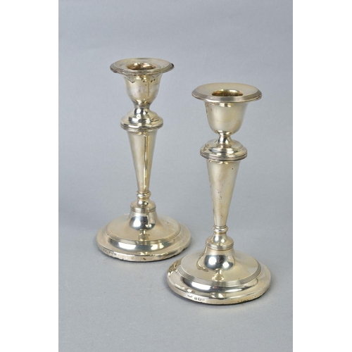 101 - A NEAR PAIR OF EDWARDIAN SILVER CANDLESTICKS, concentric band decoration to rims, inverted conical s... 