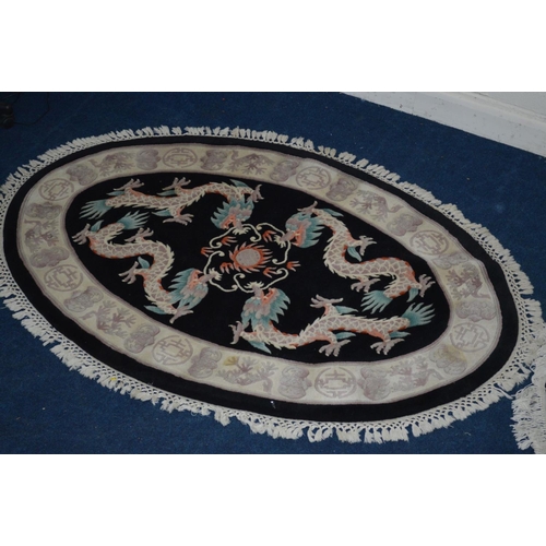 1291 - A LARGE G H FIRTH OVAL WOOLLEN CHINESE BLACK GROUND RUG, 250cm x 160cm and a similar smaller rug (2)