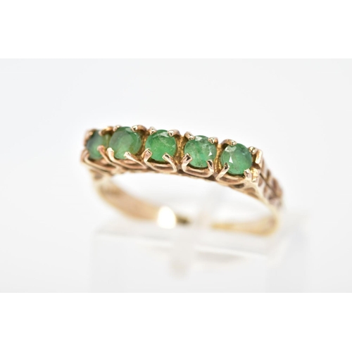 52 - A 9CT GOLD EMERALD RING, set with a row of five circular cut emeralds to the engraved shoulders, wit... 