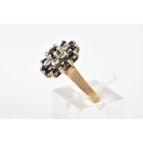 58 - A 9CT GOLD SAPPHIRE AND DIAMOND RING, of cluster design set with thirteen circular cut sapphires and... 