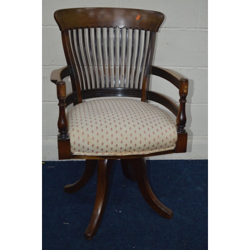 1203 - AN EARLY 20TH CENTURY WALNUT SPINNING OFFICE CHAIR, with a spindle back, turned arm rests, on four o... 