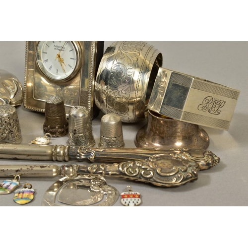 122 - A QUANTITY OF SILVER ITEMS, including two napkin rings, silver handled button hooks, two silver thim... 