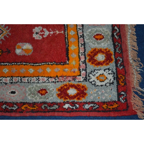 1367 - A WOOLLEN RED AND ORANGE GROUND RUG, 220cm x 124cm