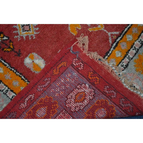 1367 - A WOOLLEN RED AND ORANGE GROUND RUG, 220cm x 124cm