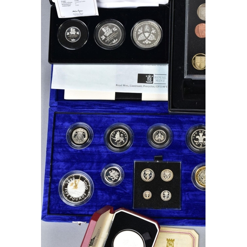 154 - A CARDBOARD BOX CONTAINING UK ROYAL MINT COIN PROOF SETS to include two three cased one pound silver... 