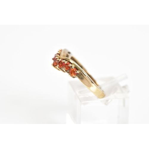 29 - A 9CT GOLD GEM RING, the v-shape ring is claw set to the front with seven circular orange gems, 9ct ... 