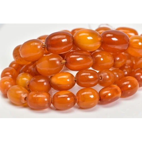 3 - A NATURAL AMBER BEAD NECKLACE, fifty fine oval beads graduating in size from 9mm x 5.5mm to 16mm x 1... 