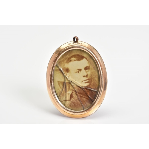 36 - AN EARLY 20TH CENTURY ROLLED GOLD PHOTOGRAPH PENDANT, of oval outline with photograph panels to eith... 