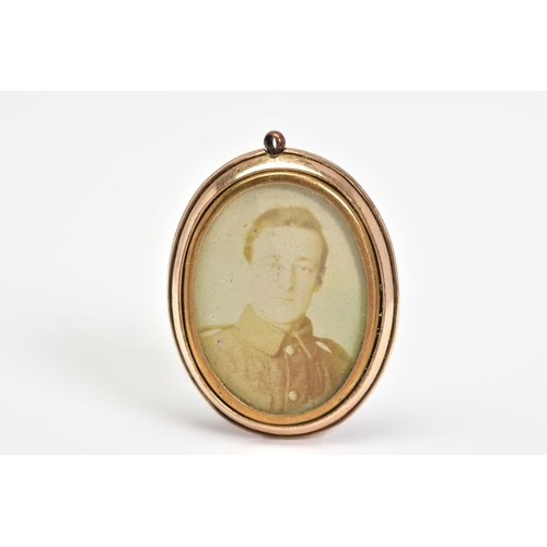 36 - AN EARLY 20TH CENTURY ROLLED GOLD PHOTOGRAPH PENDANT, of oval outline with photograph panels to eith... 