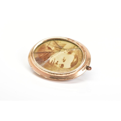 36 - AN EARLY 20TH CENTURY ROLLED GOLD PHOTOGRAPH PENDANT, of oval outline with photograph panels to eith... 