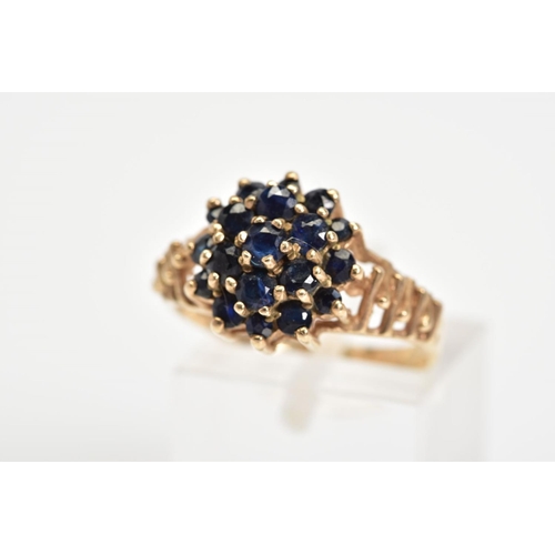 37 - A 9CT GOLD SAPPHIRE CLUSTER RING, designed as a tiered cluster of claw set circular sapphires to the... 