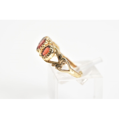 39 - A 9CT GOLD PASTE RING, designed as three oval red pastes to the bifurcated shoulders with further sc... 