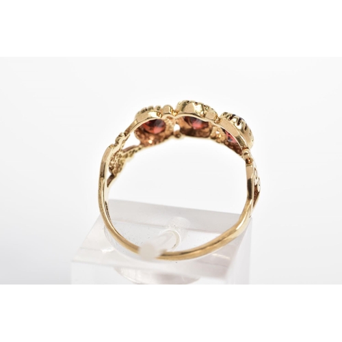 39 - A 9CT GOLD PASTE RING, designed as three oval red pastes to the bifurcated shoulders with further sc... 