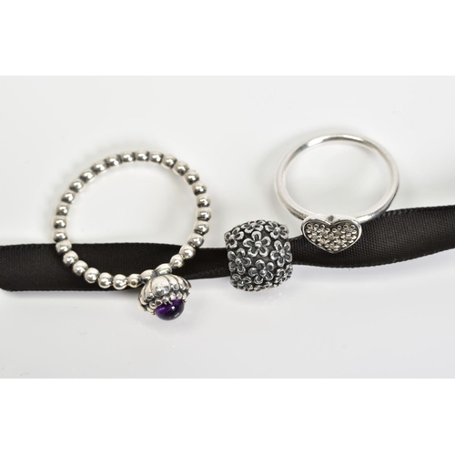 43 - TWO PANDORA RINGS AND A CHARM, the first ring designed with a central amethyst to the beaded band, r... 