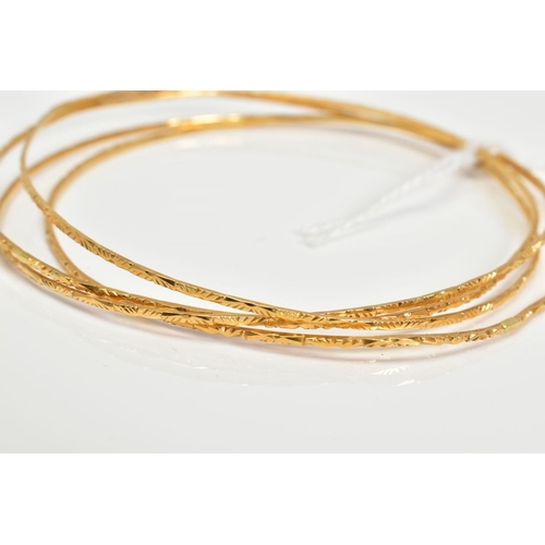 6 - FOUR 18CT GOLD BANGLES, comprising a set of thin bangles with engraved detail, all with 18ct import ... 