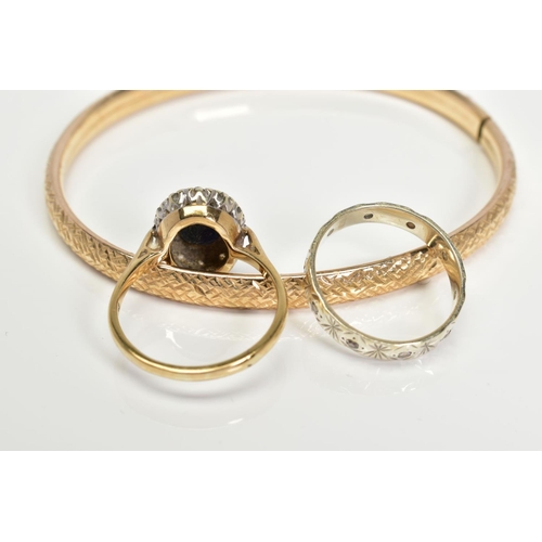 7 - A 9CT GOLD BANGLE AND TWO RINGS, the hollow flexible bangle with diamond cut engraved decoration, th... 