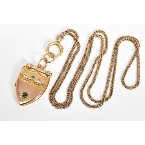 14 - AN EARLY 20TH CENTURY GOLD SHIELD SHAPED LOCKET, set with green and white paste stone, together with... 