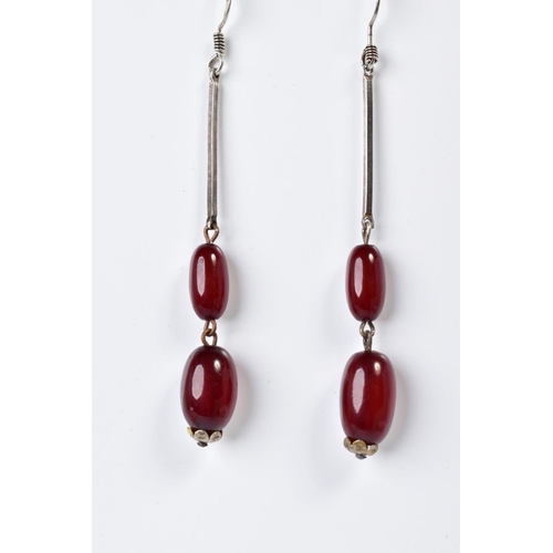 171 - A PAIR OF EARLY 20TH CENTURY CHERRY AMBER SET DROP EARRINGS, designed as two graduated ovoid beads s... 