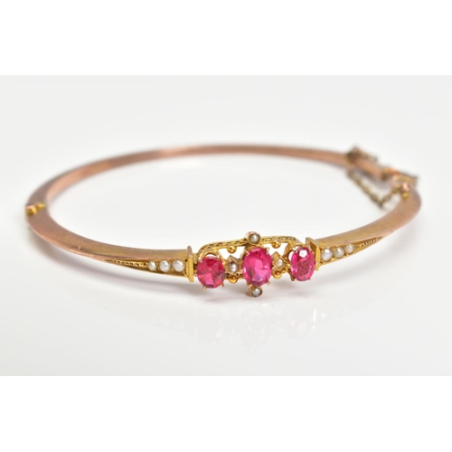 3 - AN EARLY 20TH CENTURY GOLD SPLIT PEARL AND GARNET TOPPED DOUBLET FANCY BANGLE, measuring approximate... 