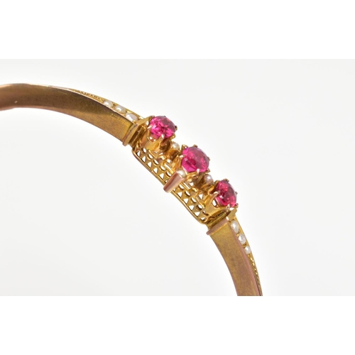 3 - AN EARLY 20TH CENTURY GOLD SPLIT PEARL AND GARNET TOPPED DOUBLET FANCY BANGLE, measuring approximate... 