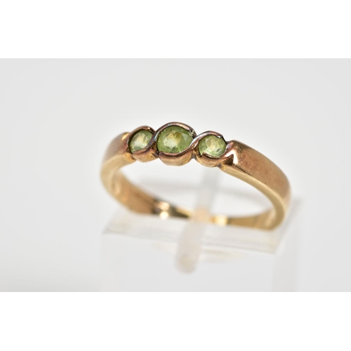 48 - A 9CT GOLD THREE STONE RING, set with three circular cut peridots within a cross over mount, to the ... 