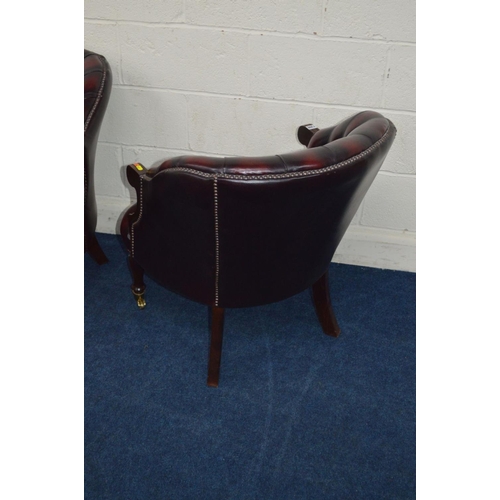 1308 - A PAIR OF MODERN OXBLOOD LEATHER BUTTON BACK ARMCHAIRS on brassed casters, width 67cm x depth 71cm x... 