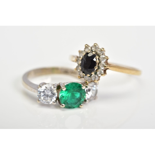 147 - TWO RINGS, the first a cluster ring set with an oval cut sapphire and colourless circular cut gemsto... 